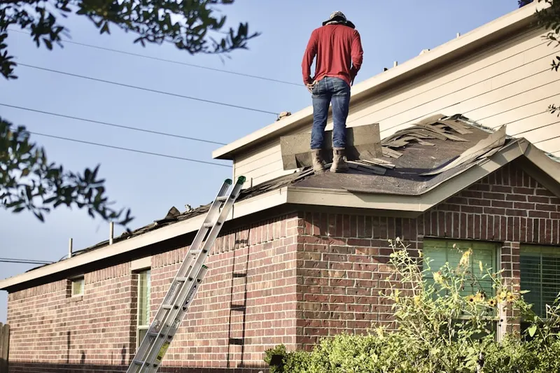Professional roofer working on a residential roof in Towne Point